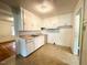Functional kitchen featuring white cabinets, laminate countertops, and ample natural light at 3810 Pendergrass St, Durham, NC 27704