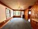 Cozy living room featuring wood paneling, fan, and carpet at 3810 Pendergrass St, Durham, NC 27704