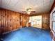 Cozy living room featuring wood paneling and blue carpet at 3810 Pendergrass St, Durham, NC 27704