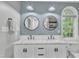 Bright bathroom features double sinks, stylish mirrors, modern lighting, and a large window at 4028 Winecott Dr, Apex, NC 27502