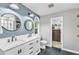 Bright bathroom featuring dual sinks, marble countertops, updated fixtures, blue accent wall, and a closet at 4028 Winecott Dr, Apex, NC 27502