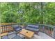 Outdoor deck features comfortable seating with a table, surrounded by lush greenery at 4028 Winecott Dr, Apex, NC 27502
