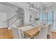 Bright dining room with hardwood floors, a modern light fixture, and a view of the staircase and living spaces at 4028 Winecott Dr, Apex, NC 27502