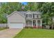 Charming two-story home with a well-maintained lawn, attached garage, and inviting front porch with classic columns at 4028 Winecott Dr, Apex, NC 27502