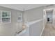 Hallway with neutral paint, carpet, two windows with blinds, and hanging light fixture at 4028 Winecott Dr, Apex, NC 27502