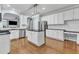 Open kitchen with stainless appliances, island, and view of living room at 4028 Winecott Dr, Apex, NC 27502