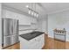 Well-lit kitchen with stainless steel refrigerator, island, and ample storage at 4028 Winecott Dr, Apex, NC 27502