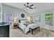 Bright main bedroom with vaulted ceiling, ceiling fan, neutral carpet, two windows, and modern decor at 4028 Winecott Dr, Apex, NC 27502