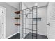 Glass enclosed shower with white subway tile and dark fixtures plus open shelves for convenient storage at 4028 Winecott Dr, Apex, NC 27502