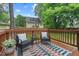 Cozy back deck with outdoor seating, a colorful rug, and a view of the fenced backyard at 415 Dupree St, Durham, NC 27707