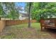 A secluded backyard featuring a wooden fence, lush greenery, and a charming wooden deck at 415 Dupree St, Durham, NC 27707