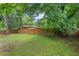 Fenced backyard with lush lawn and mature trees at 415 Dupree St, Durham, NC 27707