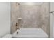 Neutral-tiled bathtub and shower combination with bronze fixtures at 415 Dupree St, Durham, NC 27707