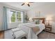Bright bedroom featuring hardwood floors, a ceiling fan, and a large window at 415 Dupree St, Durham, NC 27707