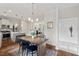 Bright dining area with wood table, elegant chandelier, and view to kitchen and living room at 415 Dupree St, Durham, NC 27707