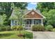 Charming blue craftsman home with a welcoming front porch, manicured landscaping and mature trees at 415 Dupree St, Durham, NC 27707