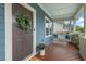 Inviting front porch with a porch swing, a green leafy wreath on the front door and nice plants at 415 Dupree St, Durham, NC 27707
