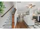 A staircase leads to the living room with hardwood floors, fireplace, white walls and a ceiling fan at 415 Dupree St, Durham, NC 27707