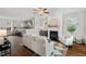An open concept living room with a fireplace, hardwood floors, a ceiling fan and neutral colored furniture at 415 Dupree St, Durham, NC 27707