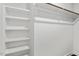 Organized walk-in closet with white shelving and wooden rods for storage and organization at 415 Dupree St, Durham, NC 27707