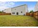 Grassy backyard with wooden fence and rear of the home at 4212 Auburn Hills Dr, Raleigh, NC 27616