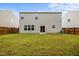 Spacious backyard with green grass, wooden fence, and the rear of the house at 4212 Auburn Hills Dr, Raleigh, NC 27616