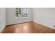 Bright bedroom featuring hardwood floors, large windows with blinds, and ample natural light at 4212 Auburn Hills Dr, Raleigh, NC 27616