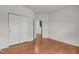 Bright bedroom featuring hardwood floors, white trim, large closet, and ample natural light at 4212 Auburn Hills Dr, Raleigh, NC 27616