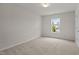 Bright bedroom featuring neutral carpet, a modern light fixture, and a large window with natural light at 4212 Auburn Hills Dr, Raleigh, NC 27616