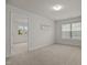 Bright bedroom featuring neutral carpet, a modern light fixture, and a view into the next room at 4212 Auburn Hills Dr, Raleigh, NC 27616