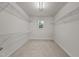 Spacious walk-in closet featuring carpet, wire shelving, and natural light from the window at 4212 Auburn Hills Dr, Raleigh, NC 27616