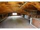 Large attic with exposed wooden beams, a window, and ample space for storage or conversion at 424 Camp Rd, Burlington, NC 27217