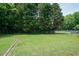 Expansive backyard with lush green grass, mature trees, and a chain-link fence at 424 Camp Rd, Burlington, NC 27217