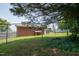 A backyard featuring a chain link fence and a covered area attached to the brick house at 424 Camp Rd, Burlington, NC 27217