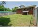 A green backyard, with a chain link fence, next to a brick house at 424 Camp Rd, Burlington, NC 27217