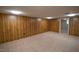 Carpeted basement with wood-paneled walls is ready for customization at 424 Camp Rd, Burlington, NC 27217