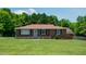 Classic brick home with a neatly kept lawn, shaded by mature trees in a serene setting at 424 Camp Rd, Burlington, NC 27217