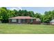 Charming single-story brick home with a well-maintained front yard and mature trees at 424 Camp Rd, Burlington, NC 27217