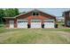 Exterior view of a brick garage with three white doors and green grass at 424 Camp Rd, Burlington, NC 27217