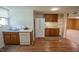 Kitchen with stainless steel sink, white appliances, oak cabinetry, and access to living area at 424 Camp Rd, Burlington, NC 27217