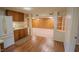 Bright kitchen with oak cabinetry, view to living area, and vinyl flooring at 424 Camp Rd, Burlington, NC 27217