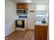 Compact kitchen featuring oak cabinets, laminate countertop, and white appliances at 424 Camp Rd, Burlington, NC 27217