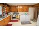 Inviting kitchen with wood cabinetry, appliances, and a convenient laundry area for seamless chores at 424 Camp Rd, Burlington, NC 27217