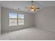 Bright bedroom features neutral carpet, a ceiling fan, and a large window overlooking the yard at 4408 Jordan Oaks Way, Raleigh, NC 27604