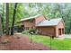 Brick home backyard featuring a screened-in porch and a lush, green lawn at 4521 Chicopee Trl, Durham, NC 27707