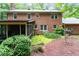 Brick home featuring a screened-in porch surrounded by lush trees and landscaping at 4521 Chicopee Trl, Durham, NC 27707