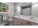 Bathroom with a double vanity, toilet, large mirror, and window at 4521 Chicopee Trl, Durham, NC 27707