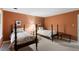 Bedroom with two beds, each with wooden frames and light colored coverings, plus neutral colored walls at 4521 Chicopee Trl, Durham, NC 27707