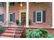 Close-up of the front entrance showing the brick steps, columns, and wooden door with decorative wreath at 4521 Chicopee Trl, Durham, NC 27707