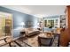 Cozy living room with blue walls, built-in bookshelves, and large windows offering a serene view at 4521 Chicopee Trl, Durham, NC 27707